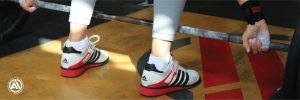 Someone about to lift a barbell while wearing CrossFit Shoes